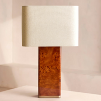 The Remi table lamp by Soho Home. Designed with a rectangular base in dark oak mappa burl timber. Complemented with a natural linen shade. Inspired by Soho House.