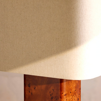 The Remi table lamp by Soho Home. Designed with a rectangular base in dark oak mappa burl timber. Complemented with a natural linen shade. Inspired by Soho House.