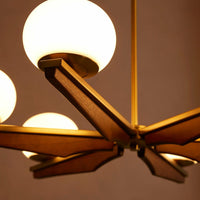 Demarco chandelier by Soho Home. Antique brass details, chandelier features six oval glass orbs, solid oak. Mid century inspired. Inspired by Soho House.