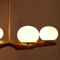 Demarco chandelier by Soho Home. Antique brass details, chandelier features six oval glass orbs, solid oak. Mid century inspired. Inspired by Soho House.