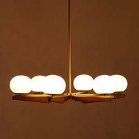 Demarco chandelier by Soho Home. Antique brass details, chandelier features six oval glass orbs, solid oak. Mid century inspired. Inspired by Soho House.