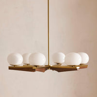 Demarco chandelier by Soho Home. Antique brass details, chandelier features six oval glass orbs, solid oak. Mid century inspired. Inspired by Soho House.