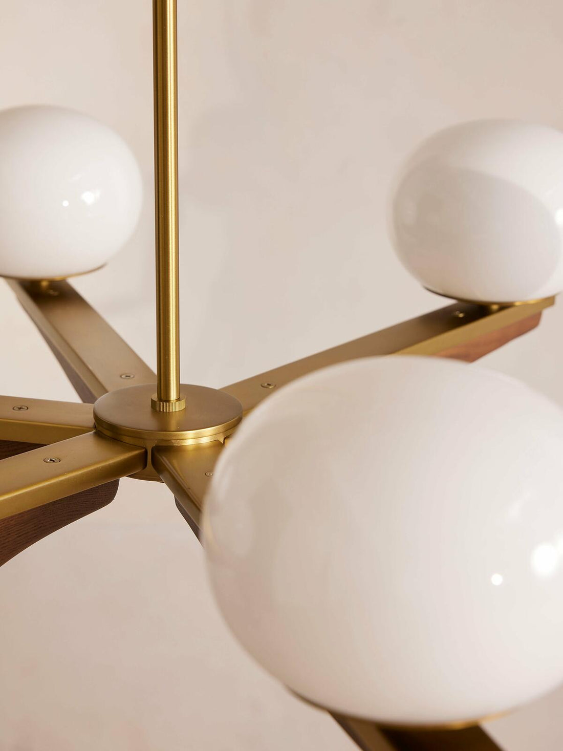 Demarco chandelier by Soho Home. Antique brass details, chandelier features six oval glass orbs, solid oak. Mid century inspired. Inspired by Soho House.