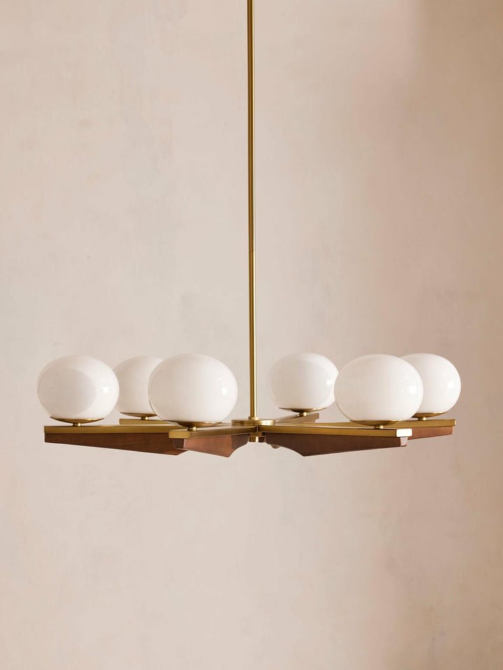Demarco chandelier by Soho Home. Antique brass details, chandelier features six oval glass orbs, solid oak. Mid century inspired. Inspired by Soho House.