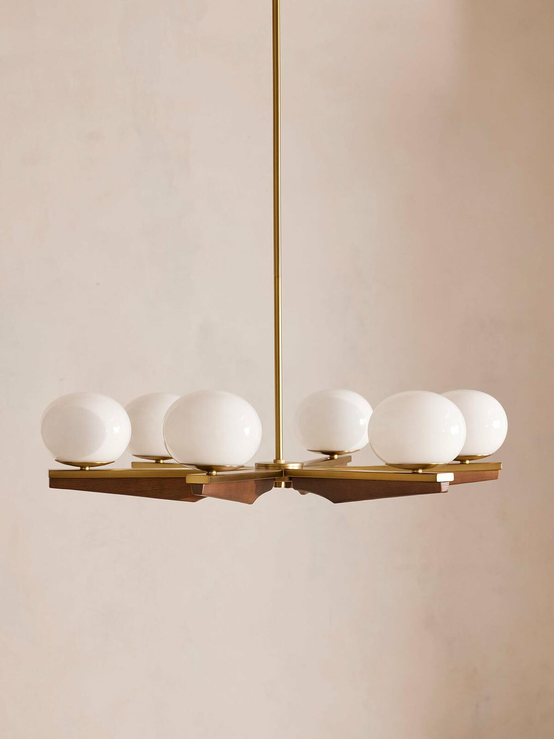 Demarco chandelier by Soho Home. Antique brass details, chandelier features six oval glass orbs, solid oak. Mid century inspired. Inspired by Soho House.